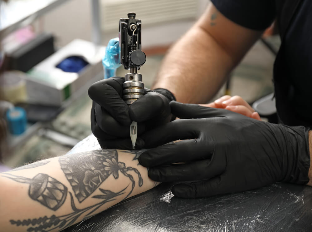 Professional artist making tattoo in salon